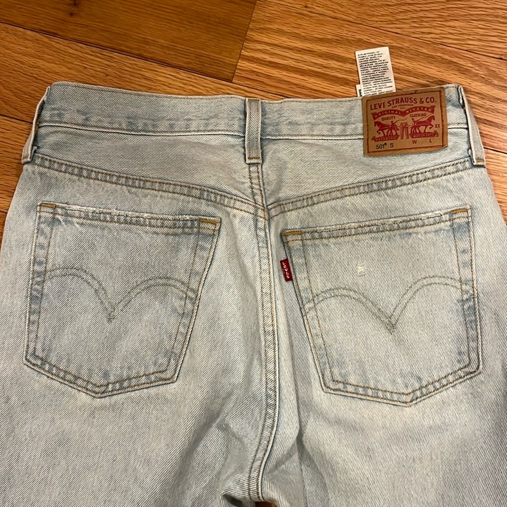 Levi 501 light wash jeans W27 L30. Straight leg, light distressing on thigh.